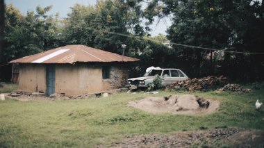Issız fakir bir köy evinde arka görünümü. Tavuk bir avlu yürüyüş mesafesindedir. Hiçbir insan. Sokakta kırık araba