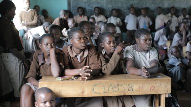 Kenya, Kisumu - 20 Mayıs 2017: Grup gülümseyen Tekdüzen sınıfta oturuyor ve düz, arıyor Afrikalı çocuk.