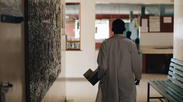 African doctor in white medical gown walking through the hospital lobby in village in Africa. Stock Image