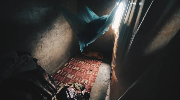 Inside a poor little house in Africa. A lot of clothes, linen lies on the concrete floor. Royalty Free Stock Photos