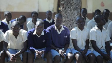 Kenya, Kisumu - 20 Mayıs 2017: Grup Afrikalı çocuk yere oturuyor. Baylar bayanlar üniformalı dışında vakit geçirmek.