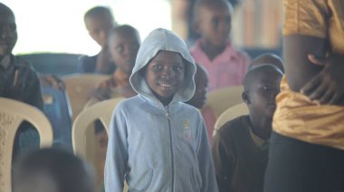 Kenya, Kisumu - 23 Mayıs 2017: Çocuk grubuyla içinde oturan ve dans, gülümseyen mutlu Afrikalı çocuk portresi.