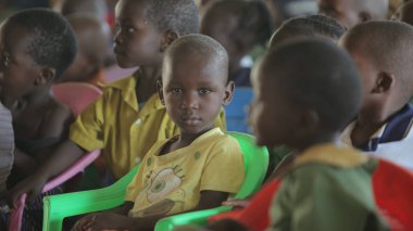 Kenya, Kisumu - 23 Mayıs 2017: Çocuk grubuyla içinde oturan ve dans, gülümseyen mutlu Afrikalı çocuk portresi.