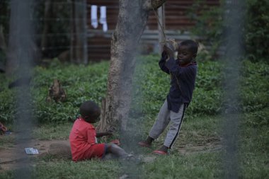 Kenya, Kisumu - 23 Mayıs 2017: Görünümü ile belgili tanımlık çit. Grup dışında vakit Afrika insan. Küçük çocuklar eğleniyor.