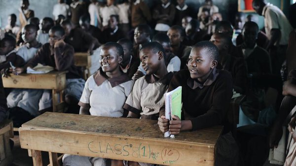 Кения, КИСУМУ - 20 мая 2017 года: Группа счастливых африканских детей, сидящих в классе и улыбающихся, смеющихся вместе
.