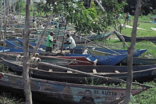 Kenia, Kisumu - 20 mei 2017: Twee Afrikaanse man zijn boot voordat het werk voorbereiden. Mensen nemen douche in het meer. — Stockfoto