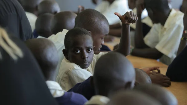 KENYA, KISUMU - 23 de maio de 2017: Vista de perto de três meninos africanos de uniforme sentados em sala de aula na escola — Fotografia de Stock