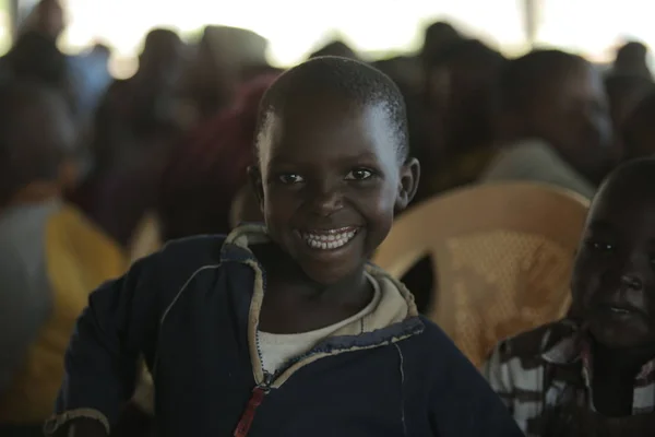Κένυα, Kisumu - 23 Μαΐου 2017: Πορτρέτο του happy Αφρικής κορίτσι συνεδρίαση μέσα με ομάδα παιδιών και χορό, χαμογελώντας. — Φωτογραφία Αρχείου
