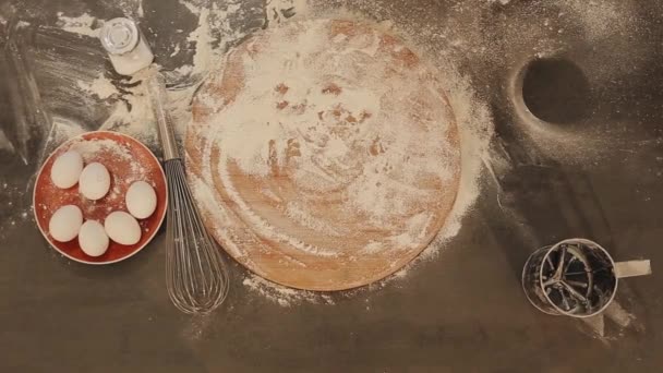 Primer plano de las manos femeninas poner pan fresco sobre la mesa. la harina se dispersa alrededor. Los huevos yacen en un plato rojo — Vídeos de Stock