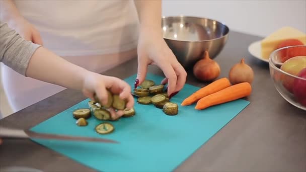 Jonge jongen snijden groenten en moeder zich dichtbij met zoon in de keuken. Close up van handen — Stockvideo