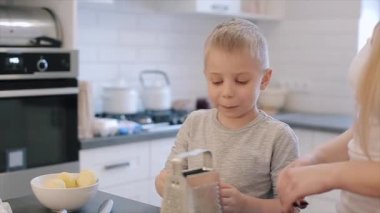 Liltle ise c mutfak peynir yeme büyük mavi gözlü çekici beyaz çocuk. Genç anne ve gri tişörtlü toghether yemek şirin güzel oğlu. Aile pizza yapma.