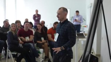 Misk, Beyaz Rusya - 23 Temmuz 2018: Beyaz peaker ekose gömlekli Sahne Alanı'nda eğitim seminer sunum ekran üzerinde konuşuyor