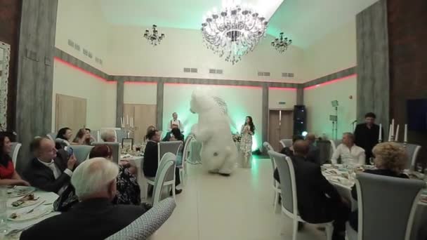 Bielorrusia, Minsk - 15 de enero de 2019: Fiesta de bodas. El hombre con un gran disfraz de oso polar está bailando en una boda con la novia y los invitados. Banquete de boda . — Vídeos de Stock