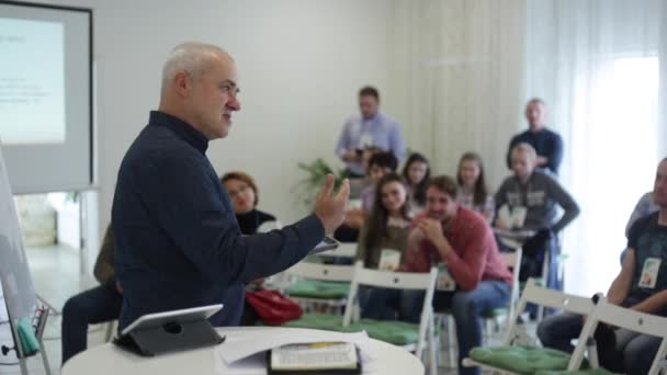 Misk, Belarus - 23 de julho de 2018: Peaker caucasiano em uma camisa xadrez está falando no palco sobre a tela de apresentação no seminário de educação — Vídeo de Stock