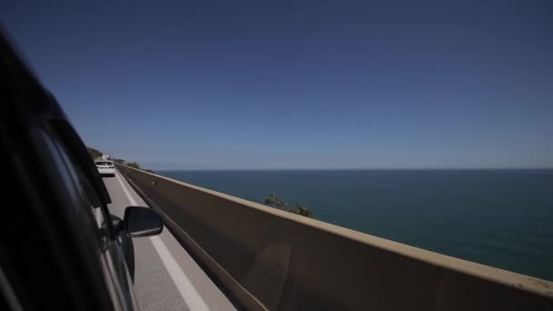 Chiudere lato auto e luce sulla strada. Guida auto sulla strada di montagna. Cavalcate in macchina con la serpentina. Mare Mediterraneo nelle vicinanze . — Video Stock