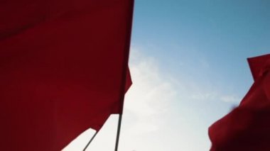 Kırmızı bayraklar karşı mavi gökyüzü sallayarak.