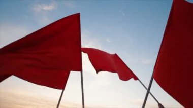 geniş açı. Bir grup insan günbatımı karşı kırmızı bayraklar sallayarak elleri.