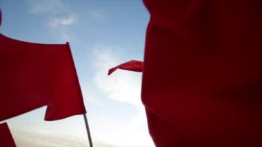 Kırmızı bayraklar karşı mavi gökyüzü sallayarak.