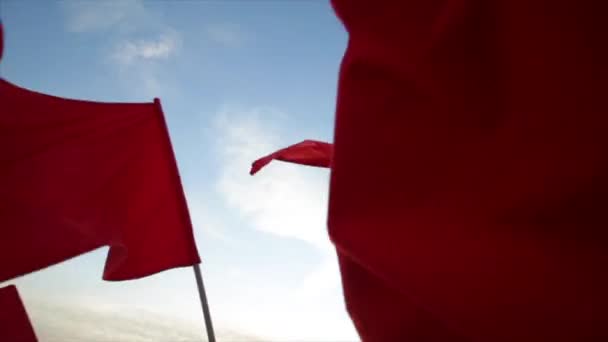 Les drapeaux rouges agitent contre le ciel bleu . — Video