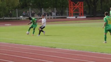 Bobruisk, Beyaz Rusya - 21 Nisan 2017: Fotball oyuncu kabaca rakip yendi. Oyuncu rakip mücadele zor. Yargıç ona sarı kart verir.