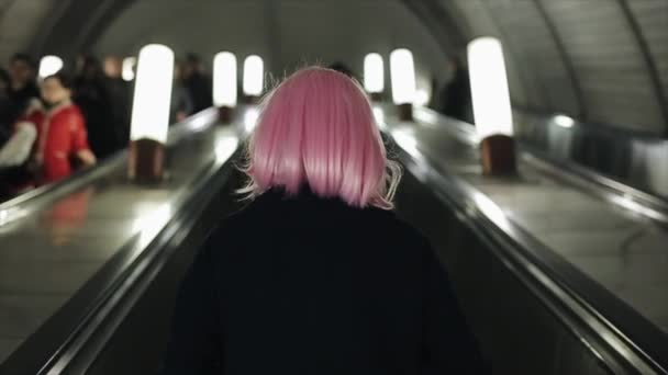 Moscú, Rusia - 10 de noviembre de 2018: Vista trasera de la mujer con el pelo rosa usando escaleras mecánicas en el metro . — Vídeos de Stock