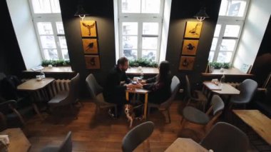 Minsk, Beyaz Rusya - 11 Ocak 2019: bir kafede genç çiftin samimi görüntü. Beyaz adam ve kadın ile bir köpek bir kafede oturuyor. İhtimal loft tarzı coffee shop.