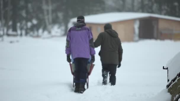 Bobruisk, Bielorussia - 12 gennaio 2019: due uomini che trasportano barile blu nel villaggio. campagna. paese. Orario invernale . — Video Stock