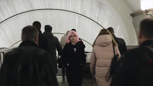 Schöne kaukasische junge Mädchen mit rosa Haaren geht durch eine Menschenmenge. Hübsche Frau mit rosa Haaren in U-Bahn. — Stockvideo