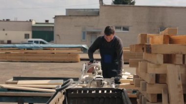 Ahşap kesme makinesi kullanarak endüstriyel genç marangoz işçisi. adam ahşap plakalar keser.