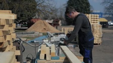 Ahşap kesme makinesi kullanarak özel üniforma endüstriyel genç marangoz işçisi.