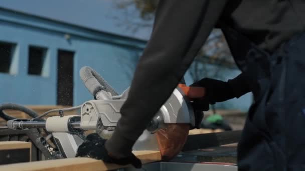 Gros plan de la machine à couper le bois coupe la planche. Ouvrier coupe des planches en bois . — Video