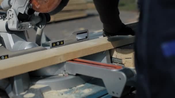 Close up of wood cutting machine cuts plank. Worker cuts wooden boards. — Stock Video