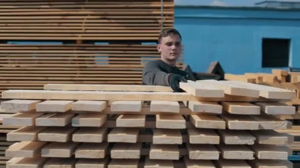 Muž se rozvine dřevěnými hobulky. Hroby čtvercových dřevěných prken pro nábytkové materiály. zrychlené natáčení. — Stock video