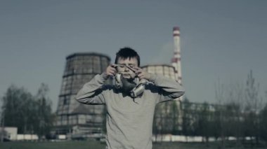 Fabrika bacalarına karşı respiratör giyen çocuk. Hava kirliliği konsepti.