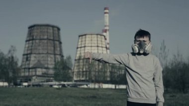hava kirliliğine karşı protesto. Genç adam fabrika bacalarına karşı parmak aşağı gösterir. Çevre sorunları çünkü genç sevmediğim gösterir.