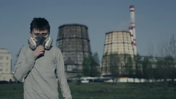 Adolescente con máscara respiratoria contra las chimeneas de fábrica. El chico se asfixia debido a la contaminación. Guy tosiendo — Vídeos de Stock