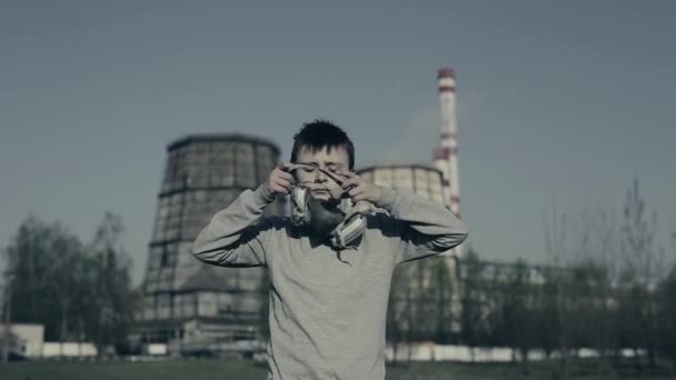 工場の煙突に対して人工呼吸器を着用している少年。大気汚染の概念. — ストック動画