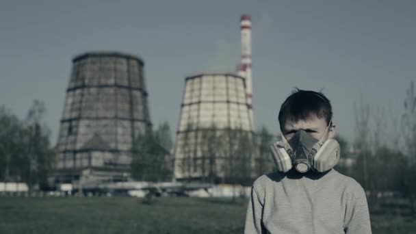 Close up retrato de menino vestindo poluição máscara contra chaminés de fábrica. Conceito de poluição atmosférica. O cara se vira e olha para a planta — Vídeo de Stock