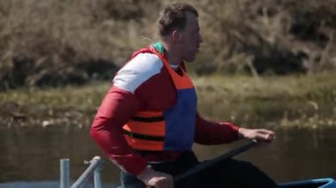 Bir kano nehirde atlet kürek portresi yakın yukarı. Kürek, Kano, kürek çekme. Eğitim. Kayak. Köprüye karşı yelken açman. Çekim Takibi