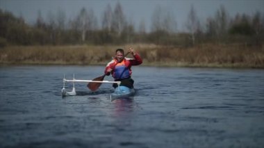 Nehirde bir kanoyla özürlü adam kürek çekiyor. Kürek, Kano, kürek çekme. Eğitim. Kayak. paraolympic spor. Yavaş hareket