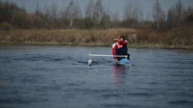 Nehirde bir kanoyla özürlü adam kürek çekiyor. Kürek, Kano, kürek çekme. Eğitim. Kayak. paraolympic spor. Yavaş hareket.