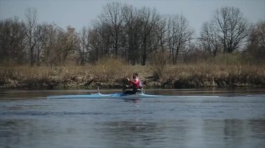 Bir kanoyla kürek çeken adam. Kürek, Kano, kürek çekme. Eğitim. Kayak. Çekim Takibi.