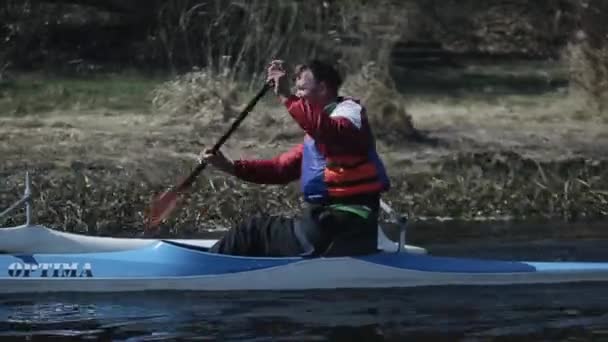 Bobruisk, Belarus - 11 May 2019: Disabled athlete rowing on the river in a canoe. Rowing, canoeing, paddling. Training. Kayaking. paraolympic sport. canoe for disabled people. Tracking shot. — Stock Video