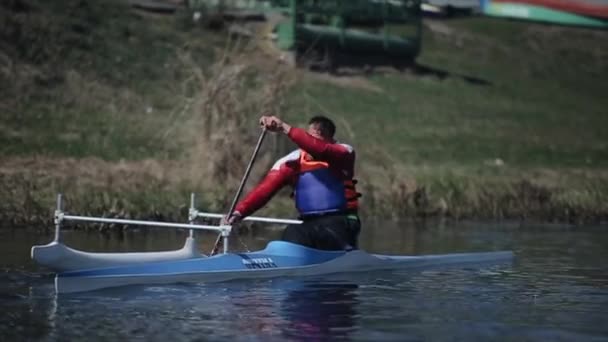 Bobruisk, Beyaz Rusya - 11 Mayıs 2019: Engelli atlet kanoyla nehirde kürek çekiyor. Kürek çekmek, kanoya binmek, kürek çekmek. Eğitim. Kayak. paraolimpik spor. engelliler için kano. İzleme çekimi. — Stok video