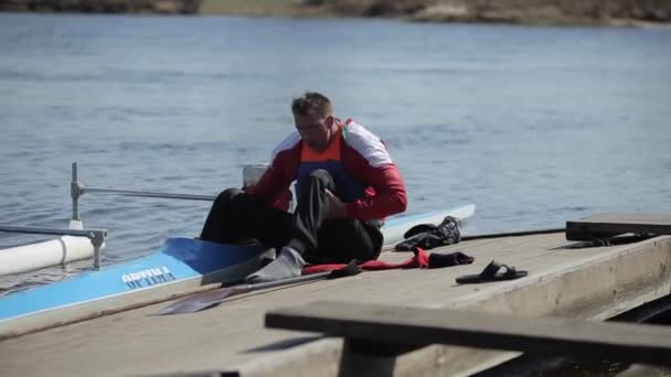 Bobruisk, Beyaz Rusya - 11 Mayıs 2019: Engelli atlet iskelede tekneden inmeye çalışıyor. Kürek çekmek, kanoya binmek, kürek çekmek. Eğitim. Kayak. — Stok video