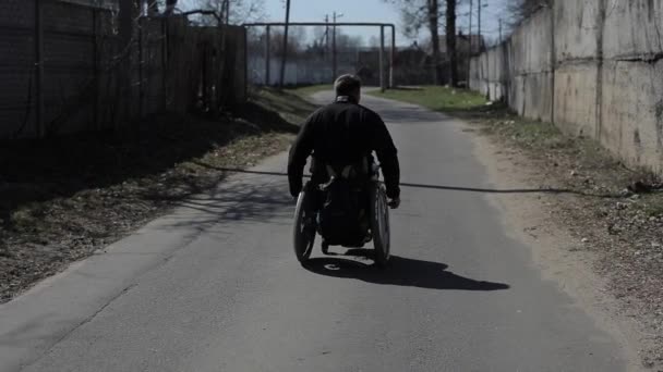 Bobruisk, Bielorrusia - 11 de mayo de 2019: hombre discapacitado en silla de ruedas en el parque. Solo tipo discapacitado . — Vídeo de stock