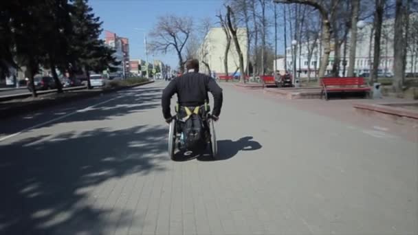 Bobruisk, Belarus - 11 May 2019: handicapped man riding wheel chair in park. Alone disabled guy. — Stock Video