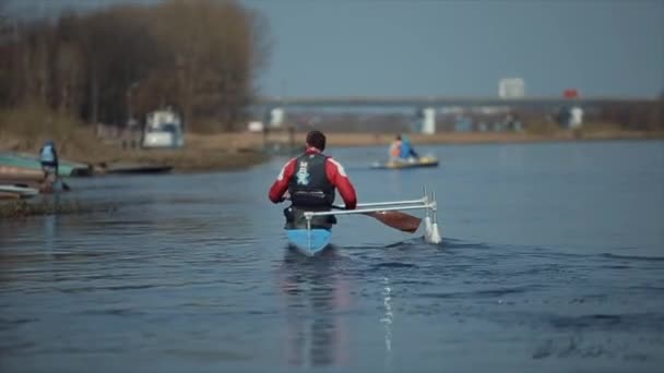 Bobruisk, Weißrussland - 11. Mai 2019: Rückansicht eines Athleten, der im Kanu auf dem Fluss rudert. Rudern, Kanufahren, Paddeln. Ausbildung. Kajakfahren. Kamerafahrt — Stockvideo