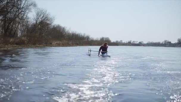 A riveren egy kenuban evezős fogyatékos ember. Evezés, kenuzás, evezés. Képzés. Kajak. paraolympic sport — Stock videók