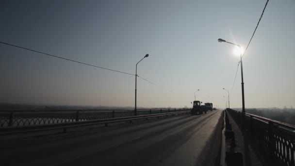 Les voitures passent sur le pont. Matin et brouillard. Un gros camion qui roule sur la route. Silhouettes de voiture — Video